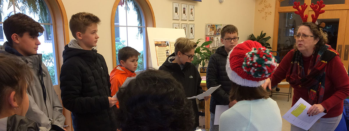 President of St. Peter SVdP Conference, Sandy Murray infuses students with holiday cheer and decorum.